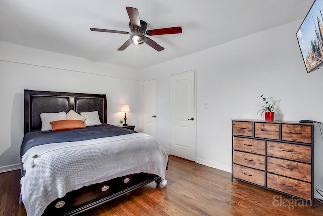 bedroom featuring a ceiling fan, baseboards, and wood finished floors