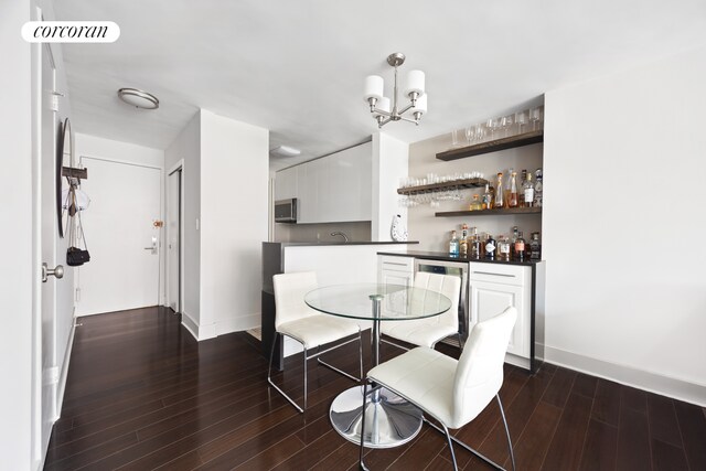 32 Gramercy Park S Unit 7F, New York City, NY 10003 - dining area with wood finished floors, baseboards, a chandelier, and a bar