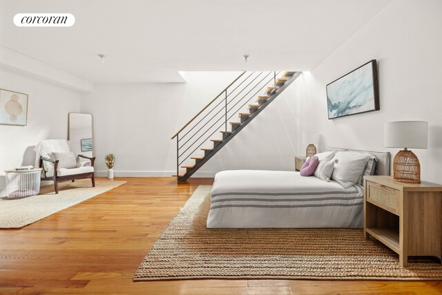 bedroom with light wood-type flooring, visible vents, and baseboards