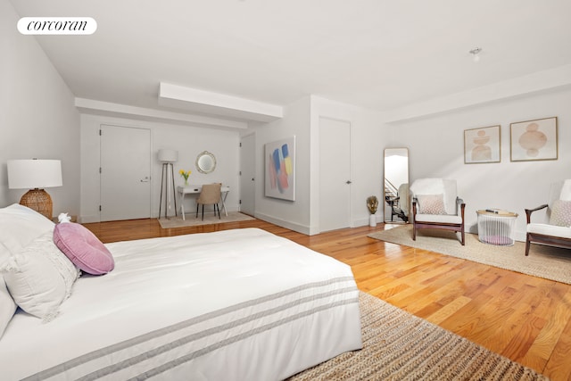 bedroom featuring wood finished floors, visible vents, and baseboards