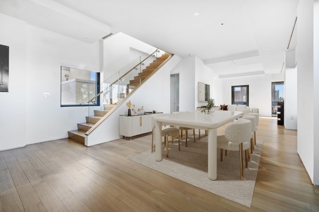 dining space with stairs and light wood-style flooring