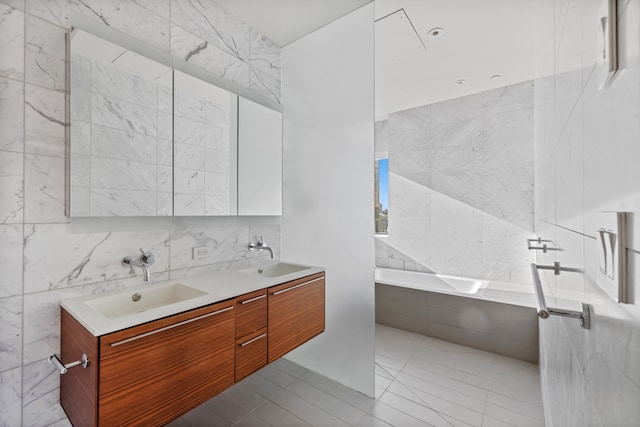 full bath featuring tiled tub, a sink, tile walls, and double vanity