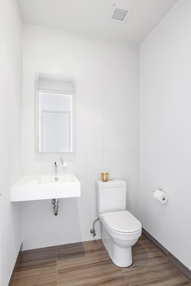 bathroom with visible vents, wood finished floors, and toilet