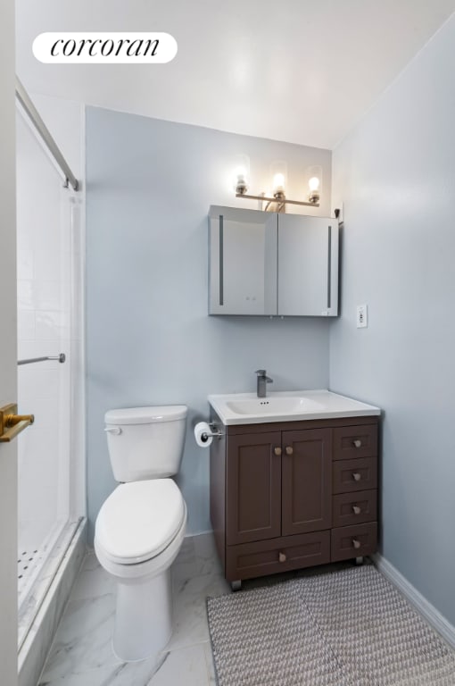 bathroom featuring a shower, vanity, and toilet