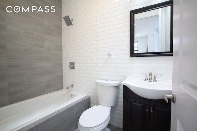 full bathroom with vanity, tiled shower / bath, backsplash, and toilet