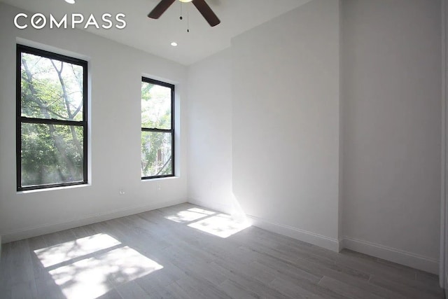 spare room with recessed lighting, baseboards, a ceiling fan, and wood finished floors