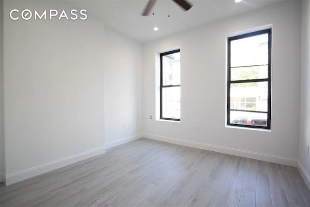 empty room featuring ceiling fan and light hardwood / wood-style floors