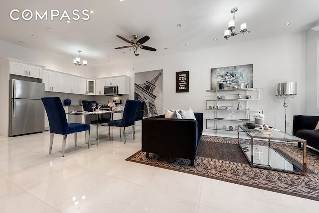 living room featuring recessed lighting, ceiling fan with notable chandelier, and light tile patterned flooring