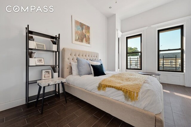 bedroom with baseboards and wood finished floors