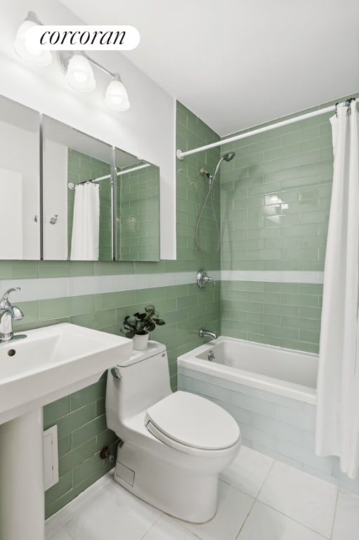 bathroom featuring toilet, tile walls, shower / bath combo with shower curtain, tile patterned flooring, and backsplash