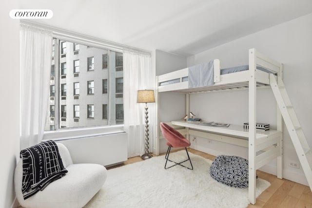 bedroom with wood finished floors, visible vents, and built in study area