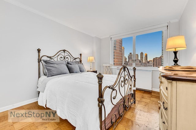 bedroom with ornamental molding, a city view, and baseboards