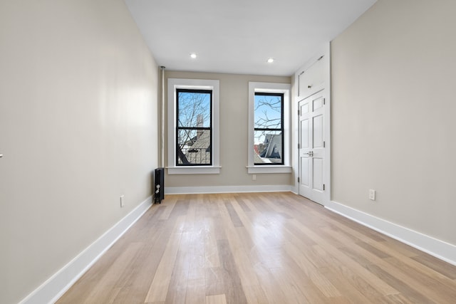 spare room featuring light wood-style floors, baseboards, and recessed lighting