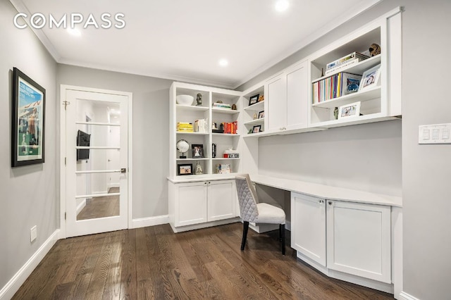 office featuring dark wood-type flooring, crown molding, and built in desk