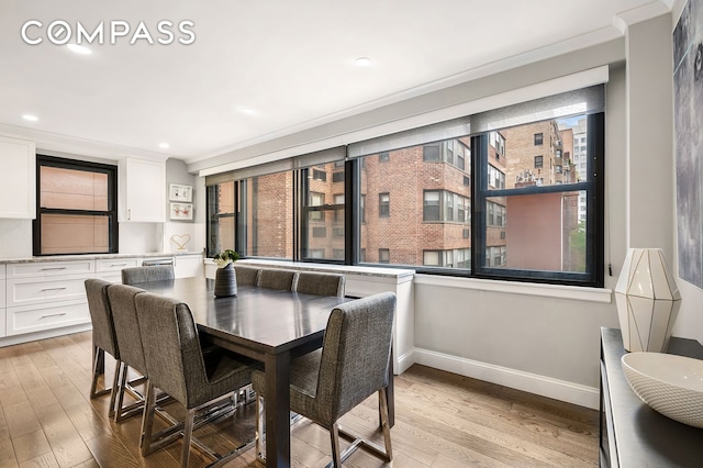 dining room with light wood-style floors, plenty of natural light, and baseboards