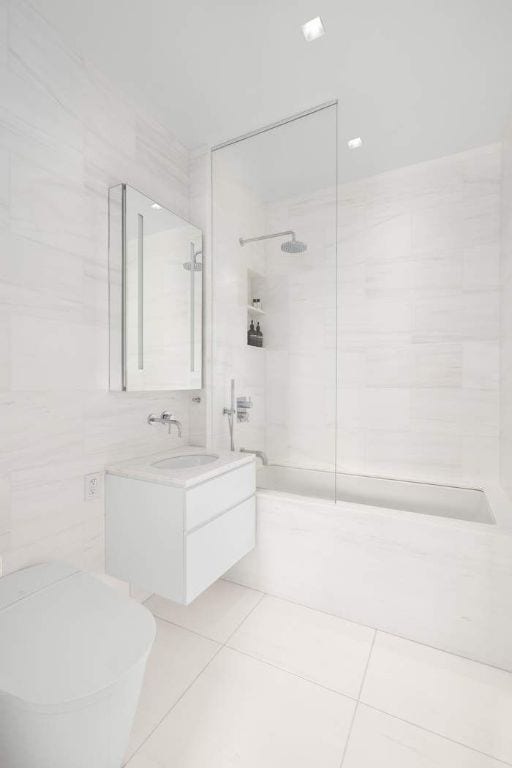 bathroom featuring tile patterned floors, toilet, vanity, and tile walls