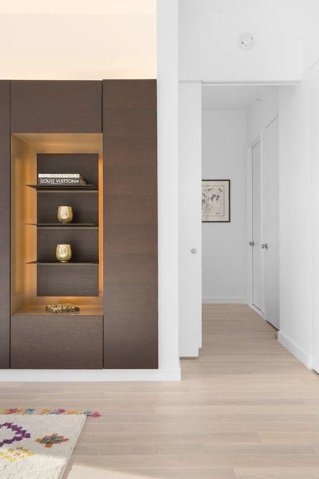 hallway featuring light wood-style floors and baseboards