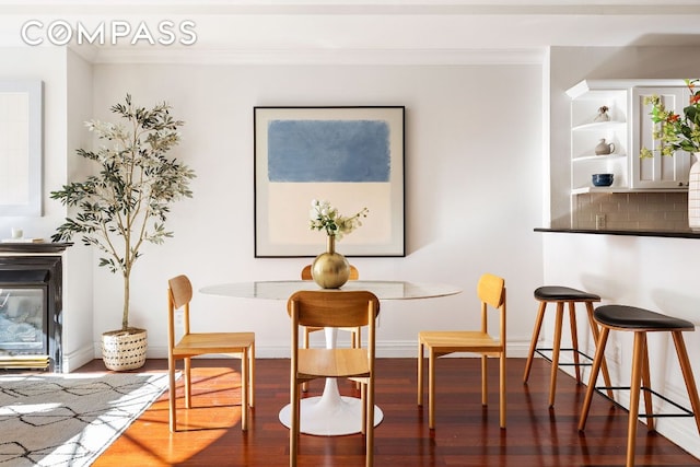 dining space with hardwood / wood-style flooring and ornamental molding