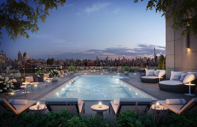 pool at dusk with a patio and an outdoor pool