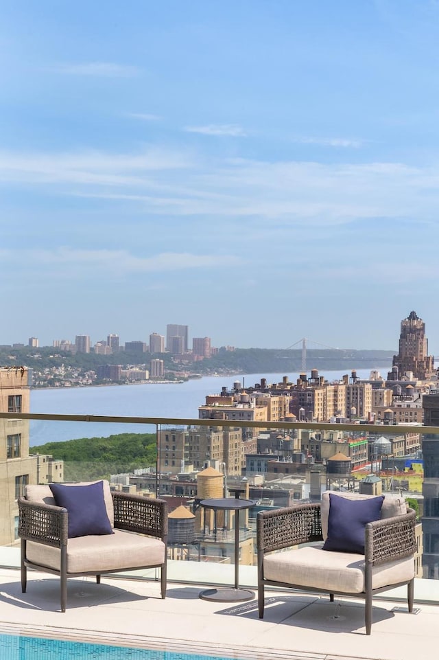 view of patio / terrace featuring an outdoor pool, a water view, and a city view