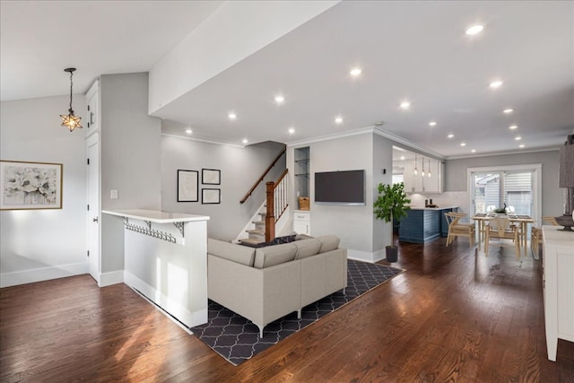 living room with dark wood-type flooring and ornamental molding