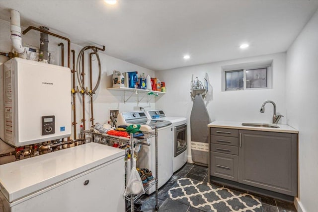 laundry area featuring separate washer and dryer, sink, cabinets, and tankless water heater