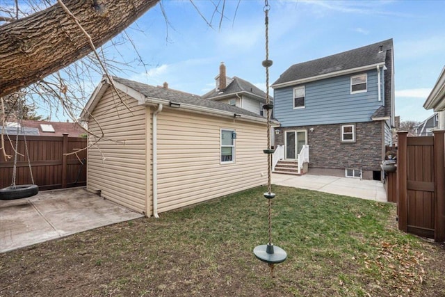 rear view of house featuring a yard and a patio