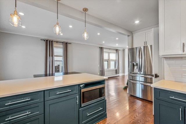 kitchen featuring pendant lighting, appliances with stainless steel finishes, backsplash, white cabinets, and dark hardwood / wood-style flooring