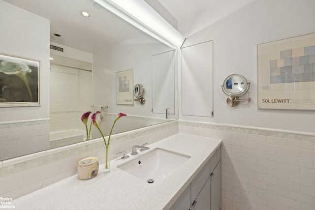 bathroom featuring vanity and tile walls