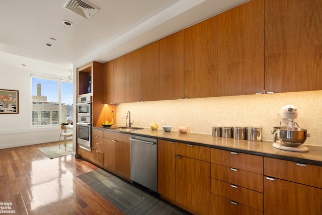 kitchen featuring stainless steel appliances, dark hardwood / wood-style floors, sink, and backsplash