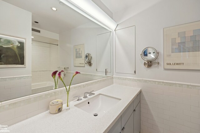 bathroom with vanity and tile walls