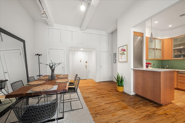 dining room featuring baseboards, recessed lighting, rail lighting, light wood-style floors, and beamed ceiling