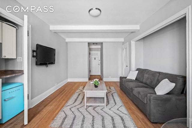 living room with hardwood / wood-style floors and beam ceiling