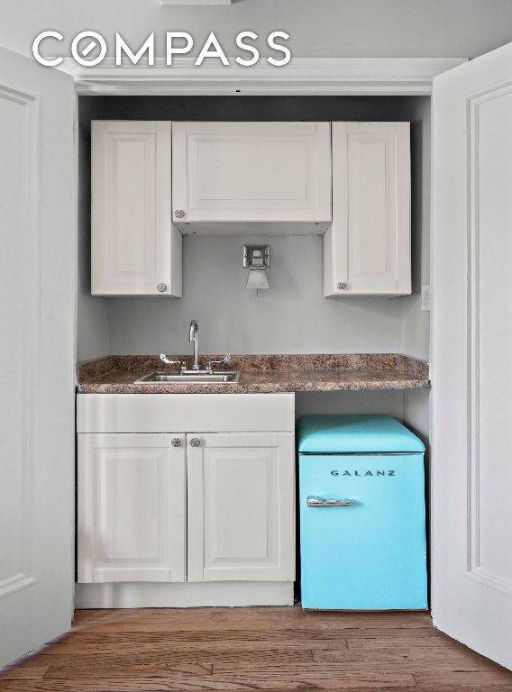 kitchen featuring sink, white cabinets, and refrigerator