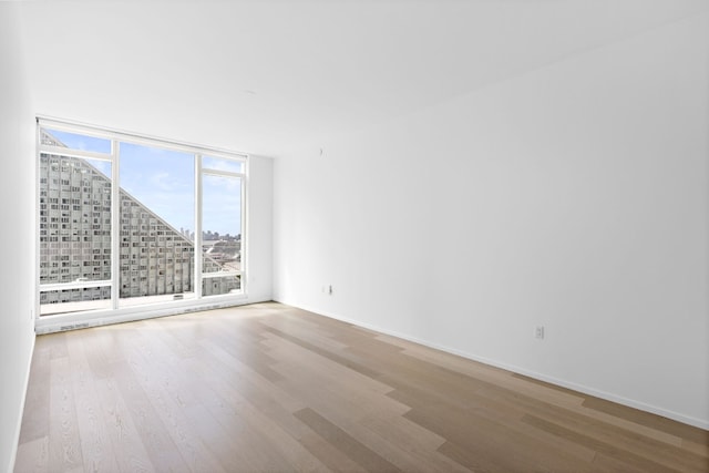 unfurnished room featuring hardwood / wood-style floors and floor to ceiling windows