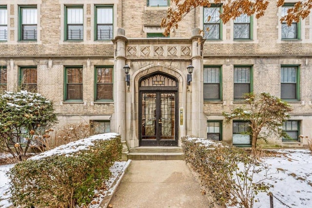 snow covered property entrance with french doors