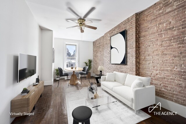 living room with hardwood / wood-style flooring, brick wall, and ceiling fan