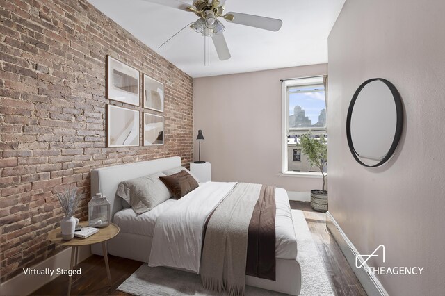 bedroom with hardwood / wood-style floors, ceiling fan, and brick wall