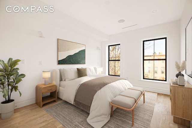 bedroom featuring light wood finished floors and baseboards