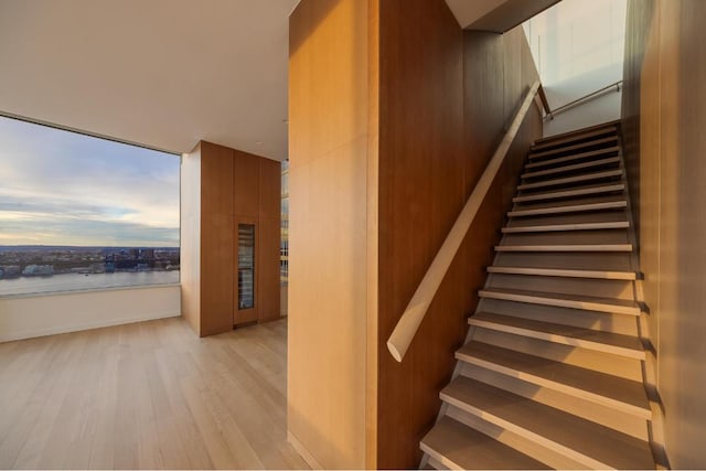 stairs with hardwood / wood-style flooring and a water view