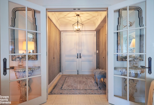 interior space featuring crown molding, a chandelier, and french doors