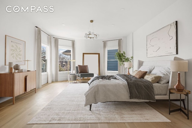 bedroom featuring a notable chandelier and light hardwood / wood-style floors