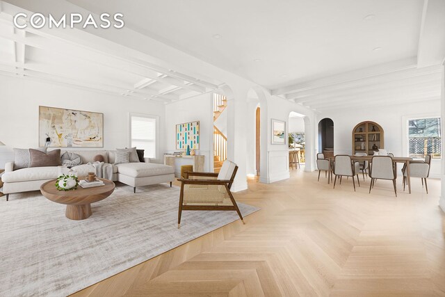 living room featuring beam ceiling and light parquet floors