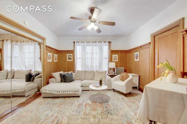 living room featuring light hardwood / wood-style flooring, plenty of natural light, ceiling fan, and wood walls