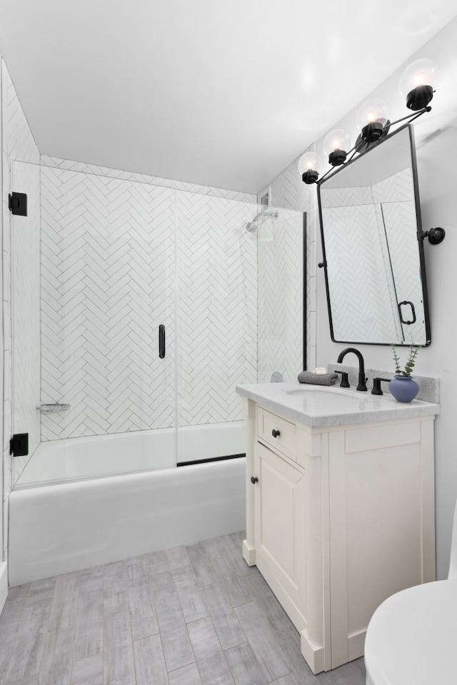 full bathroom with toilet, combined bath / shower with glass door, and vanity