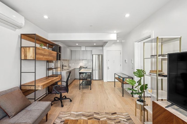 office space featuring an AC wall unit, light wood-style flooring, recessed lighting, and a sink