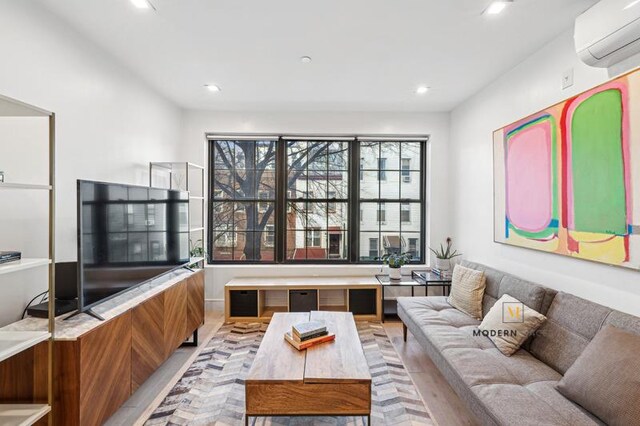 living area featuring recessed lighting and a wall mounted AC