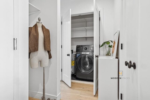 clothes washing area featuring washer / clothes dryer, wood finished floors, and laundry area