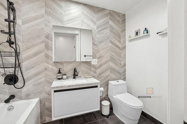 full bathroom featuring washtub / shower combination, toilet, tile walls, vanity, and tile patterned flooring