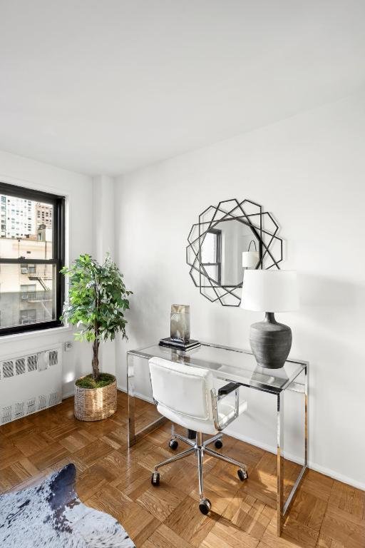 office area featuring parquet flooring and radiator heating unit